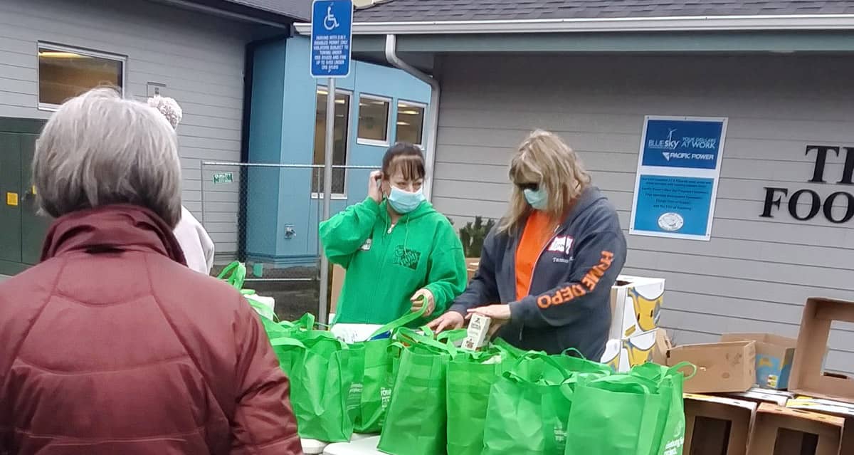 Fish Food Pantry volunteers sort green Food Project bags